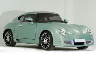 Side angle view of a small metallic green 'Hemera' sports car, white background