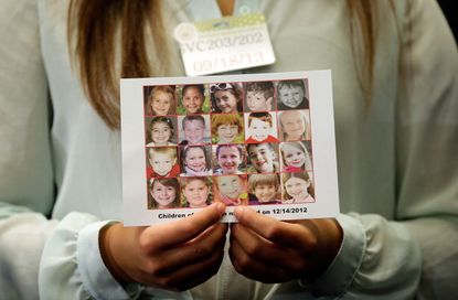A woman holds a photo showing the children who died at Sandy Hook Elementary School.