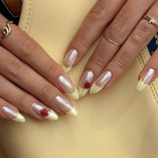 An image of a person's hands with a yellow chrome manicure.