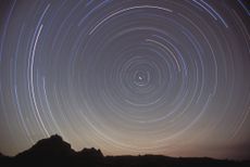 A time-lapsed, circular view of stars over Polaris above Coyote Buttes mountain range. Arizona, USA.