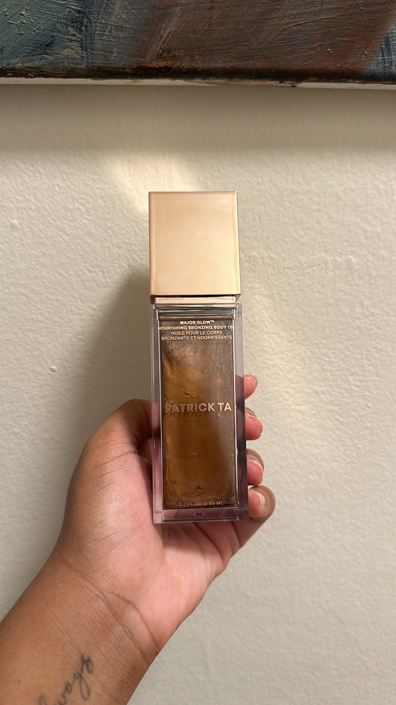 Ariel Baker testing the Patrick Ta Major Glow Nourishing Bronzing Body Oil.