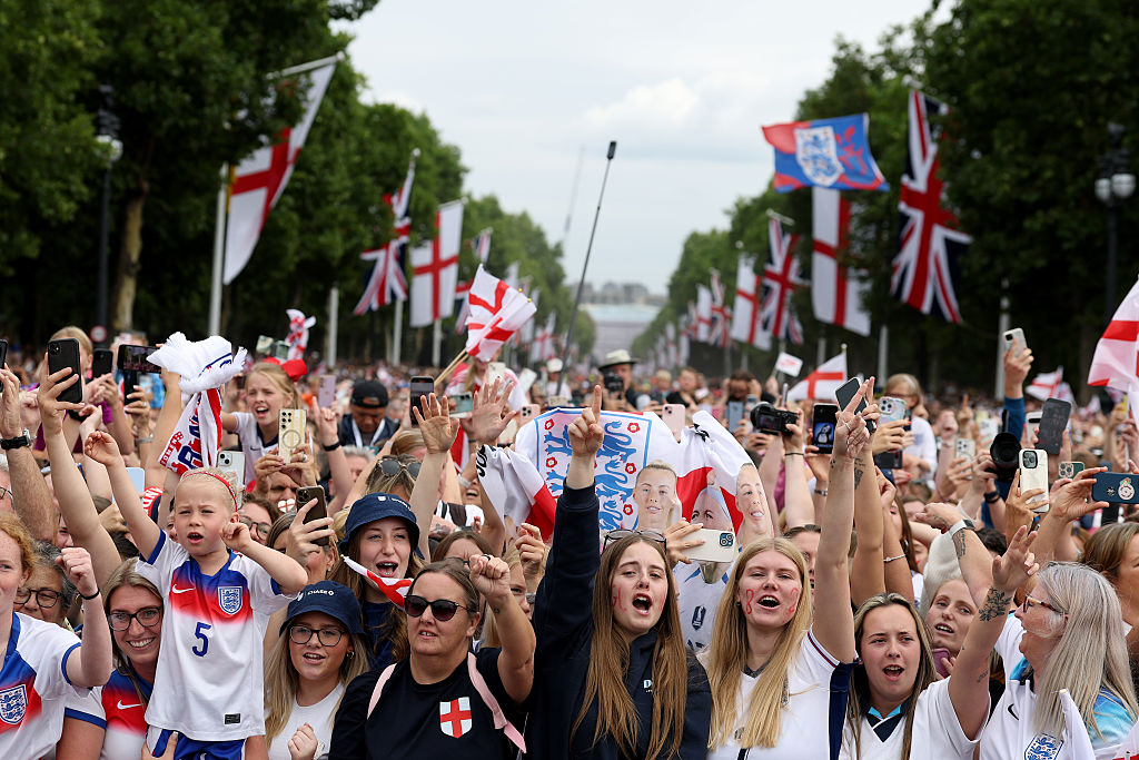 Fans of England show their support as they wait for the England Women's team victory parade and celebration on July 29, 2025 in London, England. England defeated Spain in the UEFA Women's EURO 2025 Final to retain the trophy on 27 July.