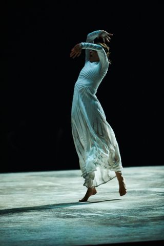 Woman wearing white Alaïa dress dancing