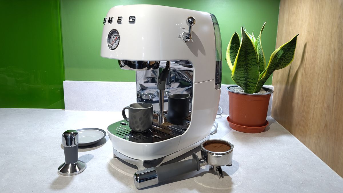Smeg ECF03 espresso machine with accessories and plant on kitchen counter
