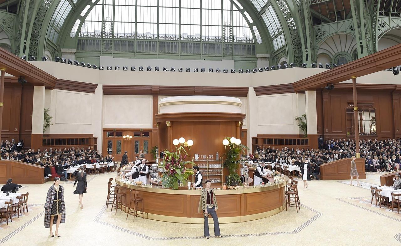 Large vaulted space with a circular bar in the centre with models walking around it. Audience in the background