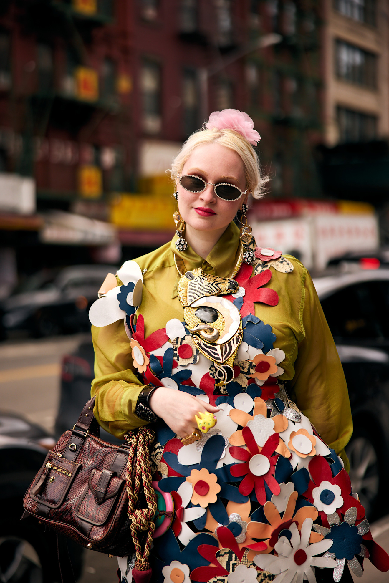 a blonde woman in a colorful dress with sunglasses and red lipstick