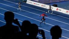Spectators watching sprinting humanoid robots during the opening ceremony of the 2nd World Robot Games in Beijing