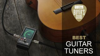 Peterson Strobe guitar tuner on a wooden floor with a Taylor acoustic guitar