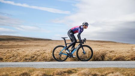 Image of female cyclist riding on a cold but sunny day