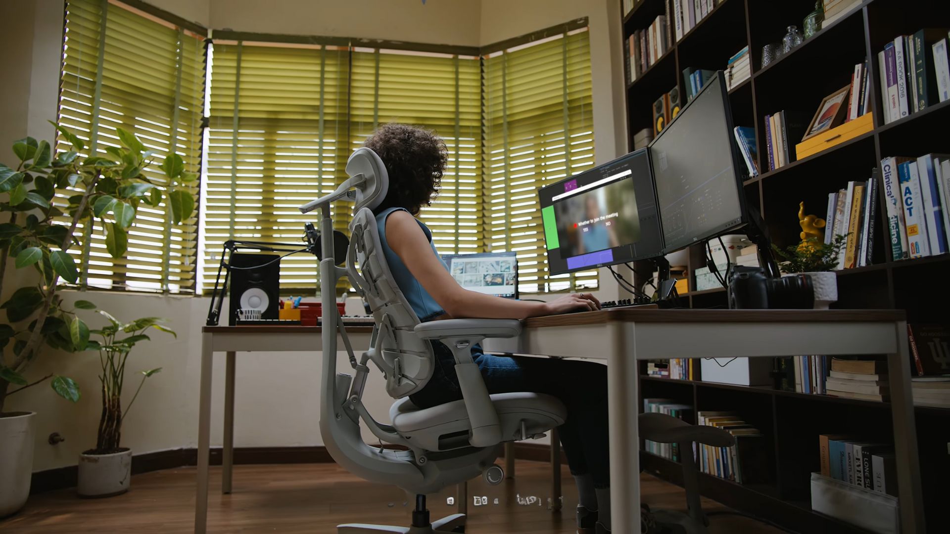 A screenshot from the LiberNovo Omni reveal video of someone sitting in it at a desk