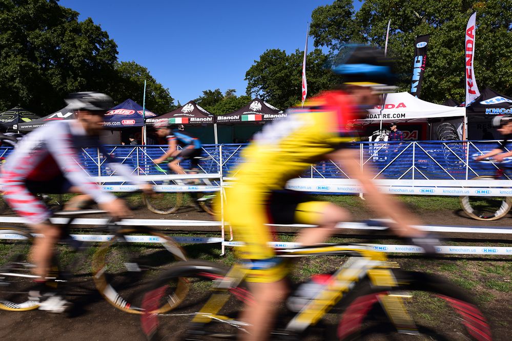 Racers making their way past the large industry expo of tents