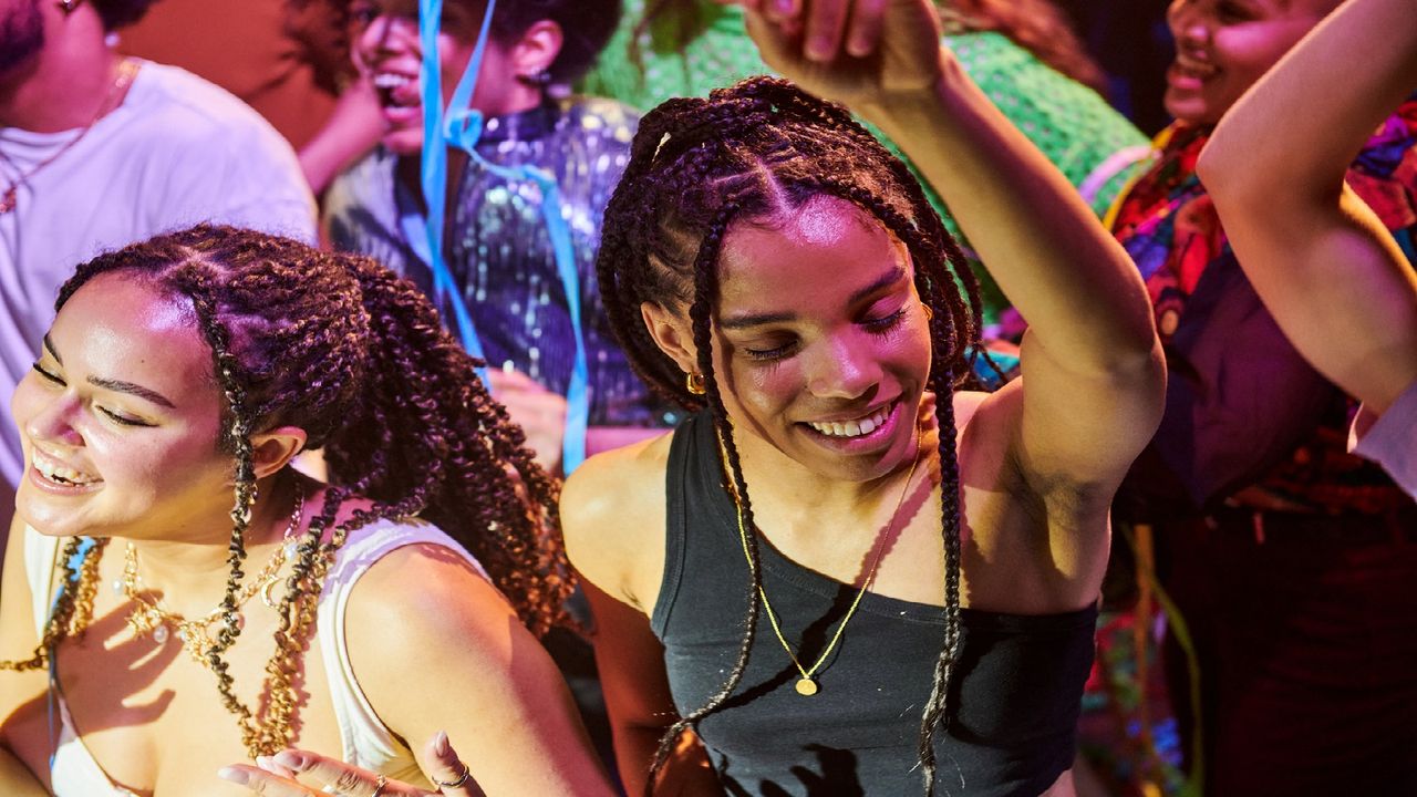 Two Gen Z Women Dance At a Concert.