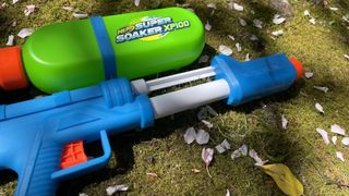 Super Soaker XP100 water blaster lying on grass