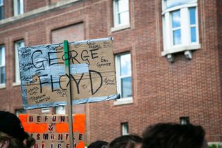 A demonstrator in Troy, New York, holds a sign listing George Floyd among the names of Black people who have died in high-profile cases.