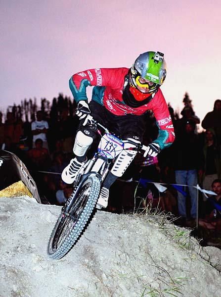Brian Buell (Team Geronimo) attacks the course with the sun setting behind him.