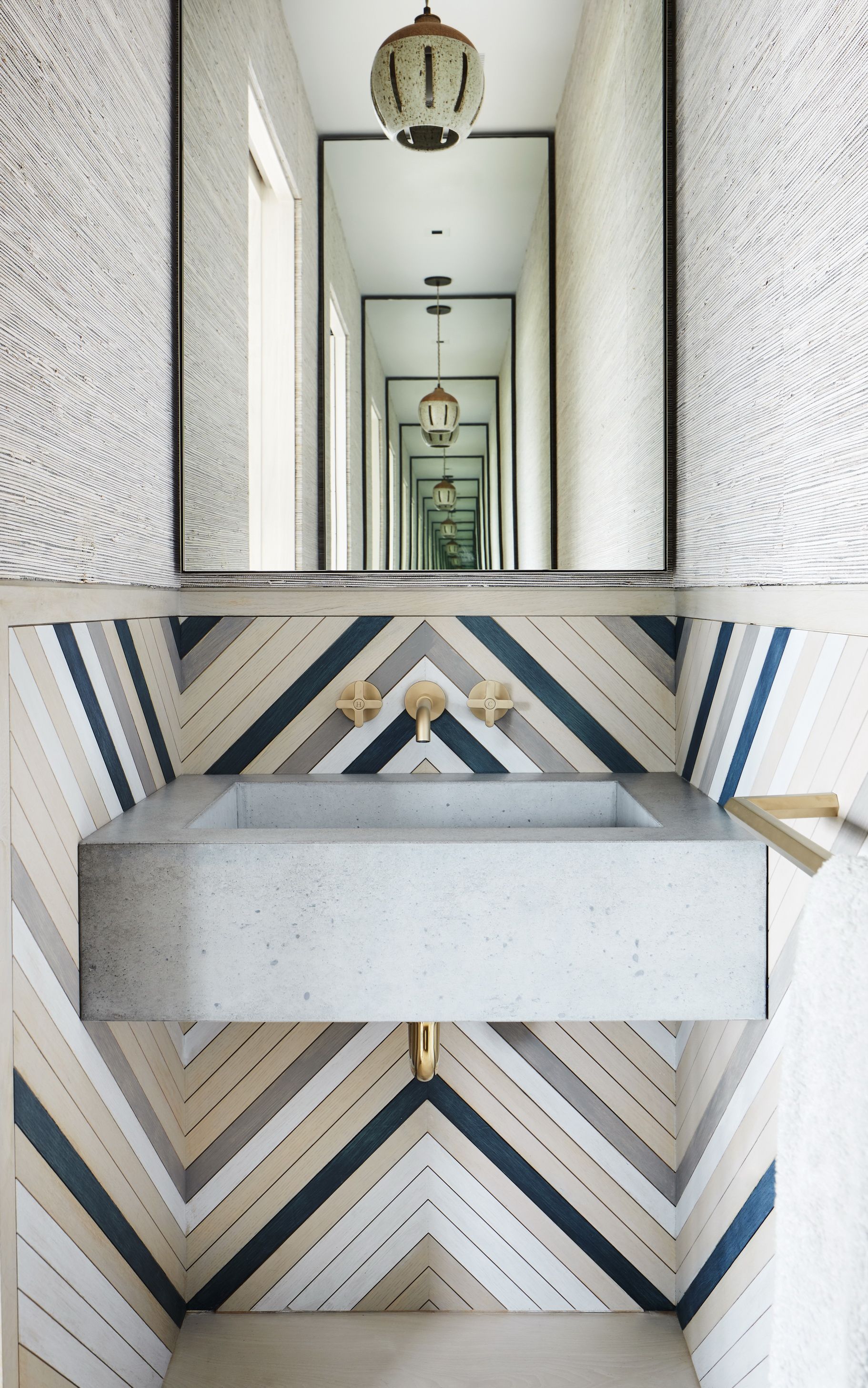 A bathroom with an angular wainscoting using different pieces of colored wood