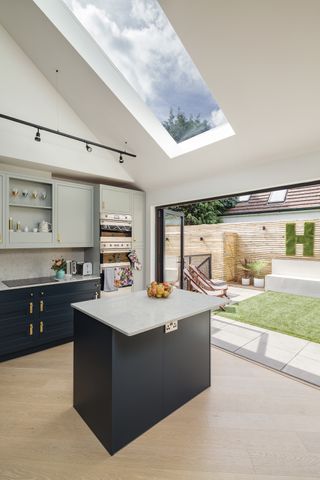 blue and white kitchen with bifold doors and rooflight