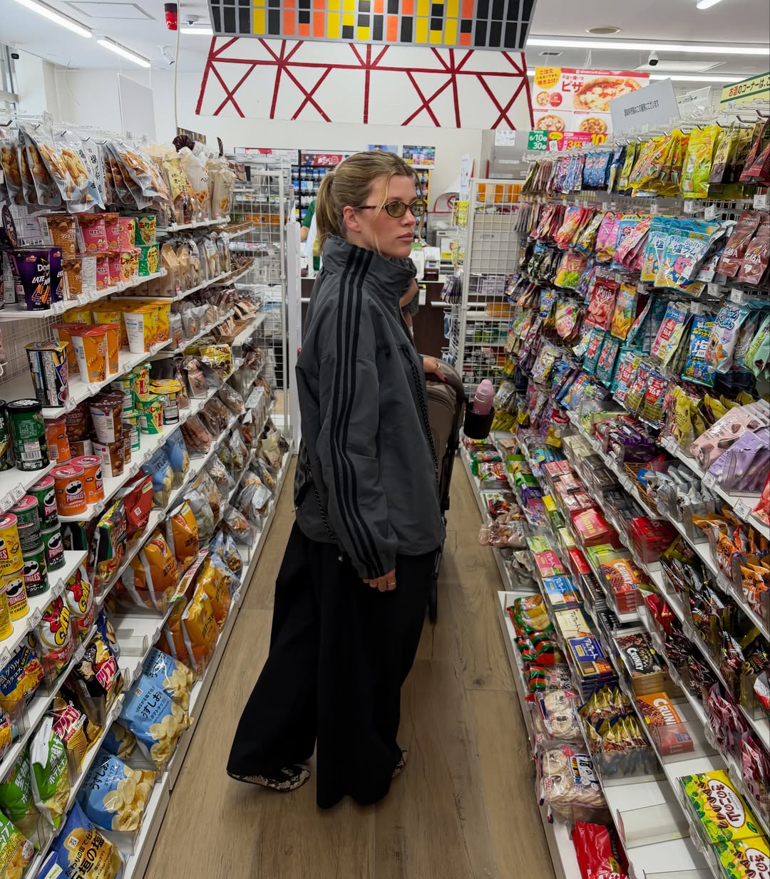 Sofia Richie Grainge shares photos wearing an Adidas track jacket, black baggy pants, and Prada snakeskin ballet sneakers, along with white shorts during a trip to Japan