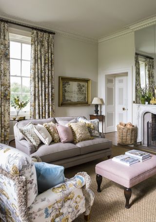Trad living room with floral drapes and matching armchair, and gray sofa with scatters.
