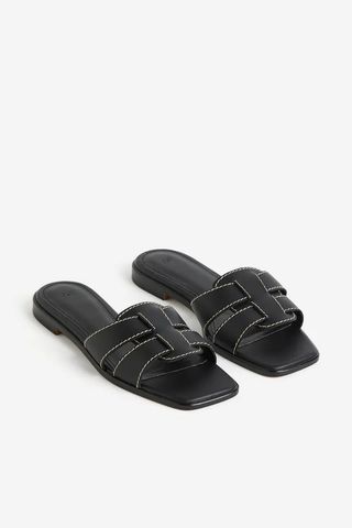 Black H&M slide sandals with white stitching