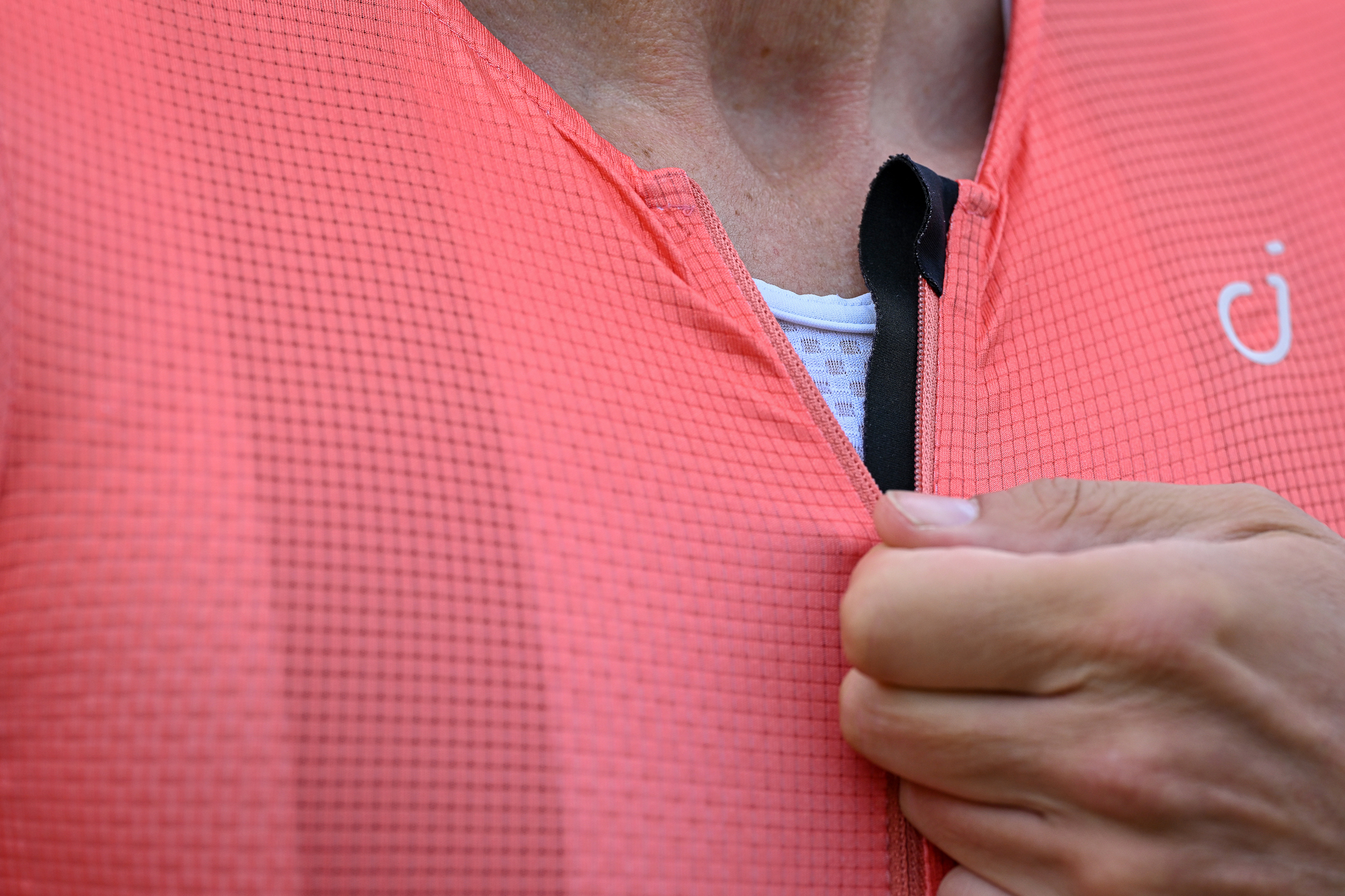close up of the zip and placket on an orange cycling jersey