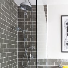 bathroom with grey tiled walls and shower on wall