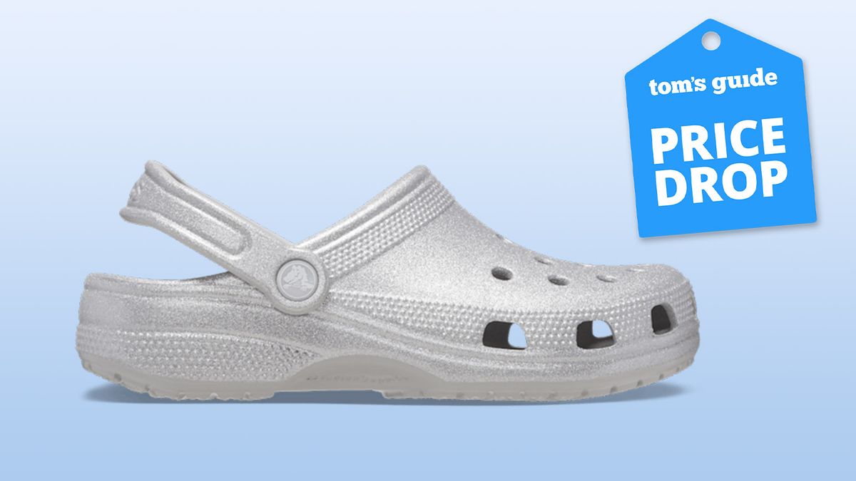 Classic Glitter Clogs Crocs in Silver Quartz on gradient blue background with Tom&#039;s Guide blue deal Price Drop badge on top right corner