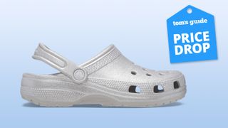 Classic Glitter Clogs Crocs in Silver Quartz on gradient blue background with Tom's Guide blue deal Price Drop badge on top right corner