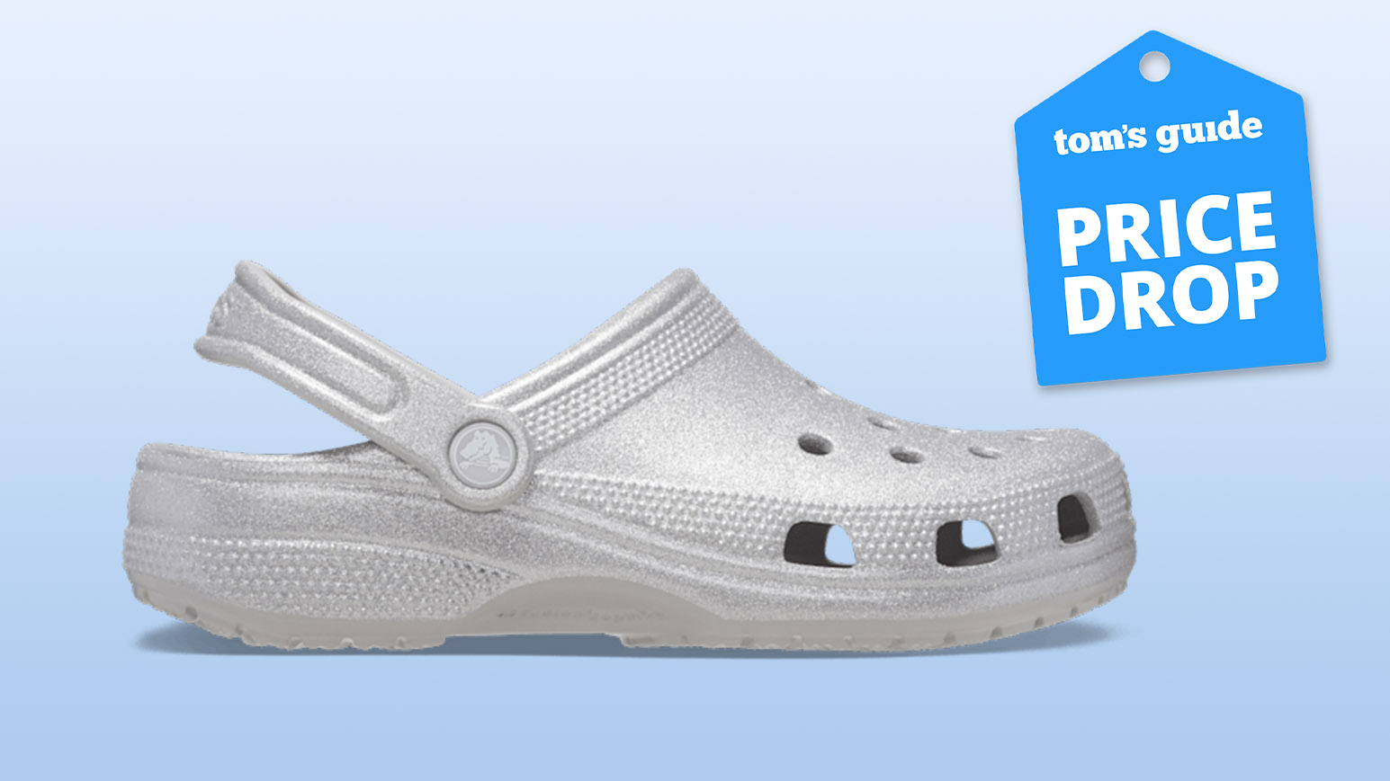 Classic Glitter Clogs Crocs in Silver Quartz on gradient blue background with Tom's Guide blue deal Price Drop badge on top right corner