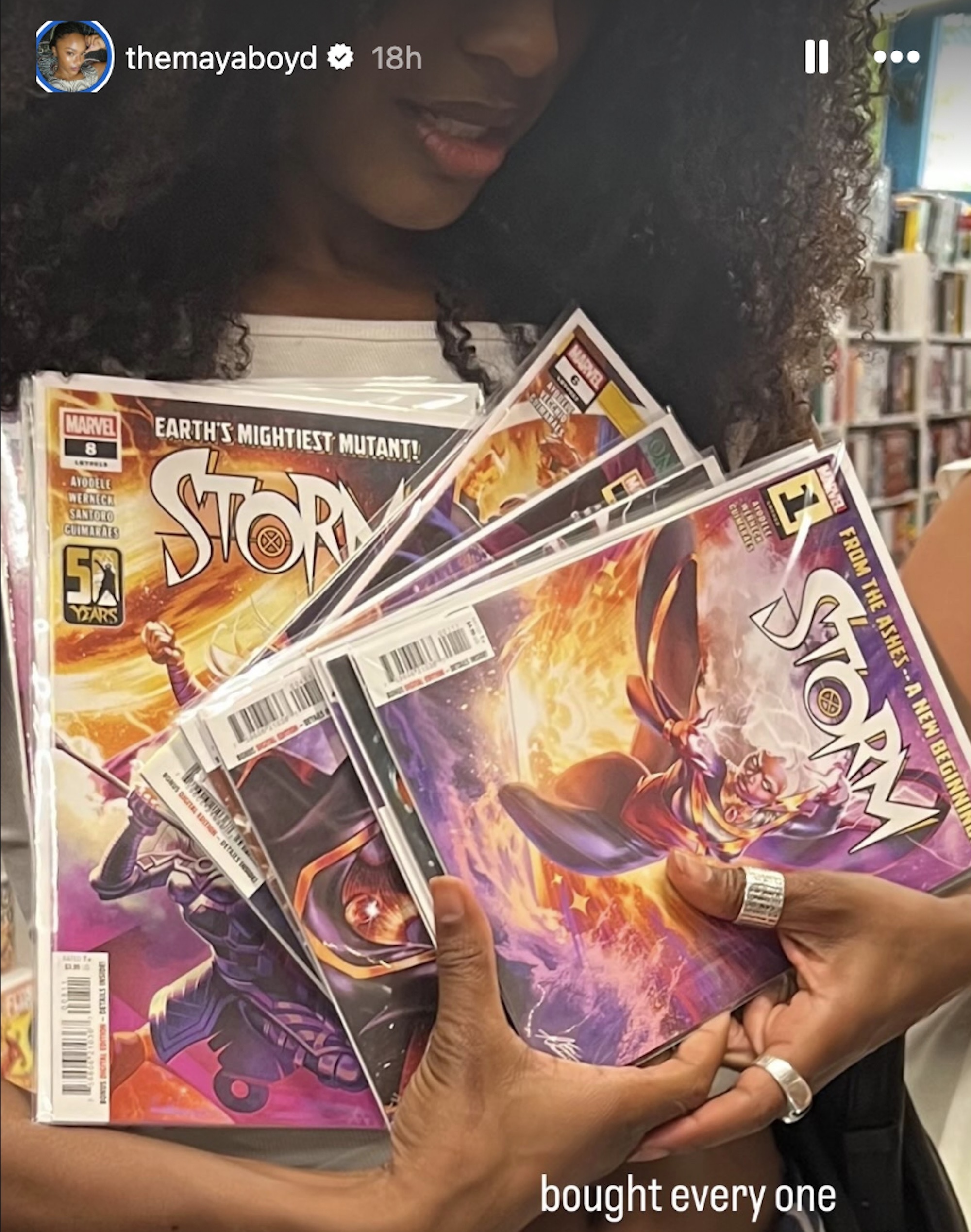 Maya Boyd holding an armful of Storm comics.
