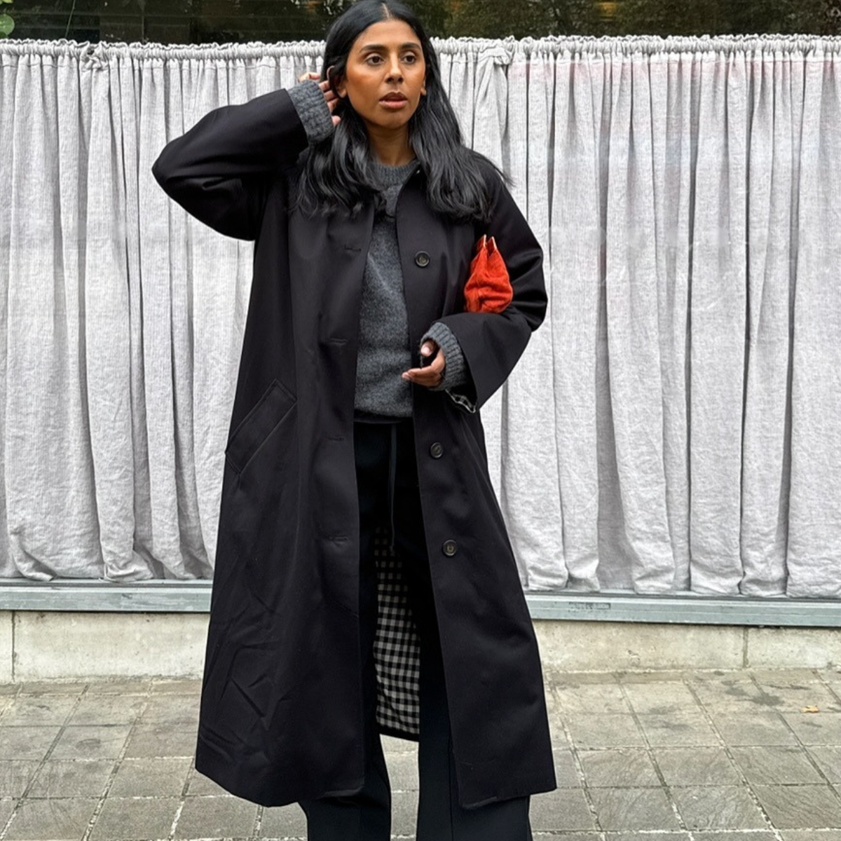 Fashion person Monikh Dale wears the black trench coat trend. 