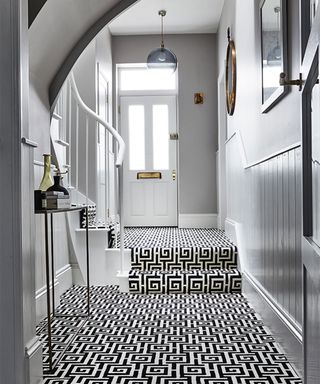 grey hallway with black and white geometric carpet