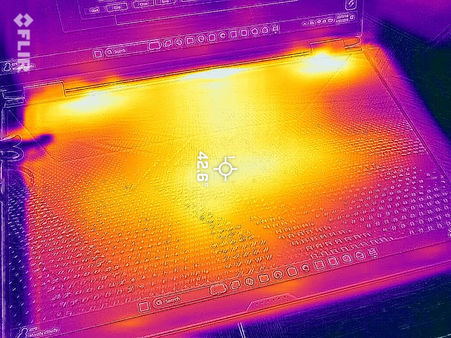 Thermal image of a laptop keyboard showing heat distribution. Bright yellow areas indicate high temperature near the center, surrounded by cooler purple zones.