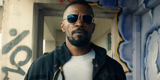 Project Power Jamie Foxx walks through a hallway with sunglasses