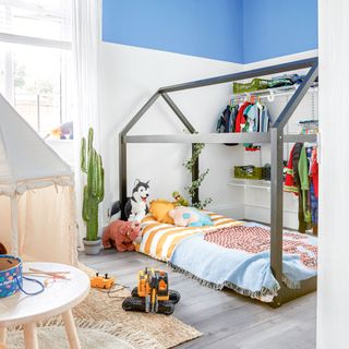 Child's bedroom with white and blue painted walls and house-shaped bed