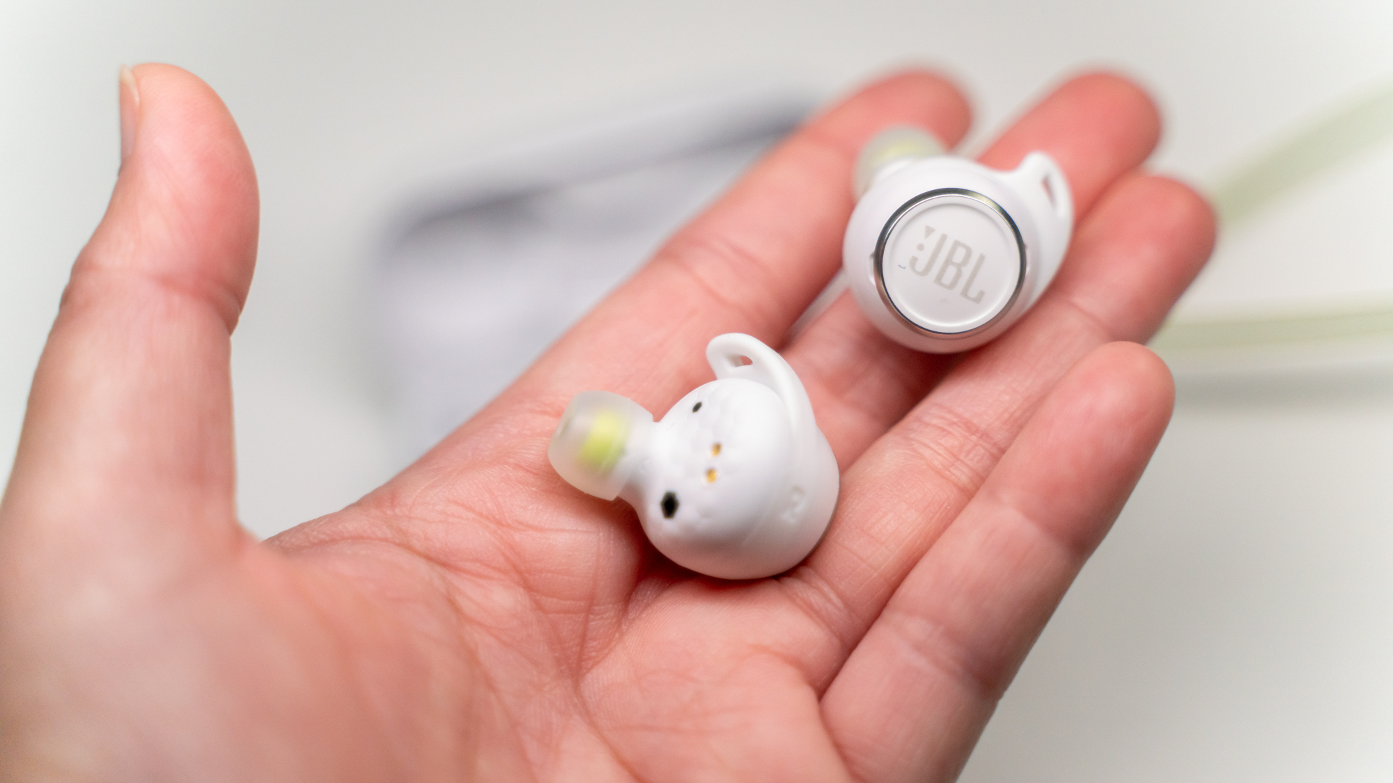 best waterproof headphones JBL Reflect Aero in reviewer's hand
