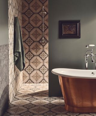 A traditional bathroom with patterned tiles on the walls and shower walls