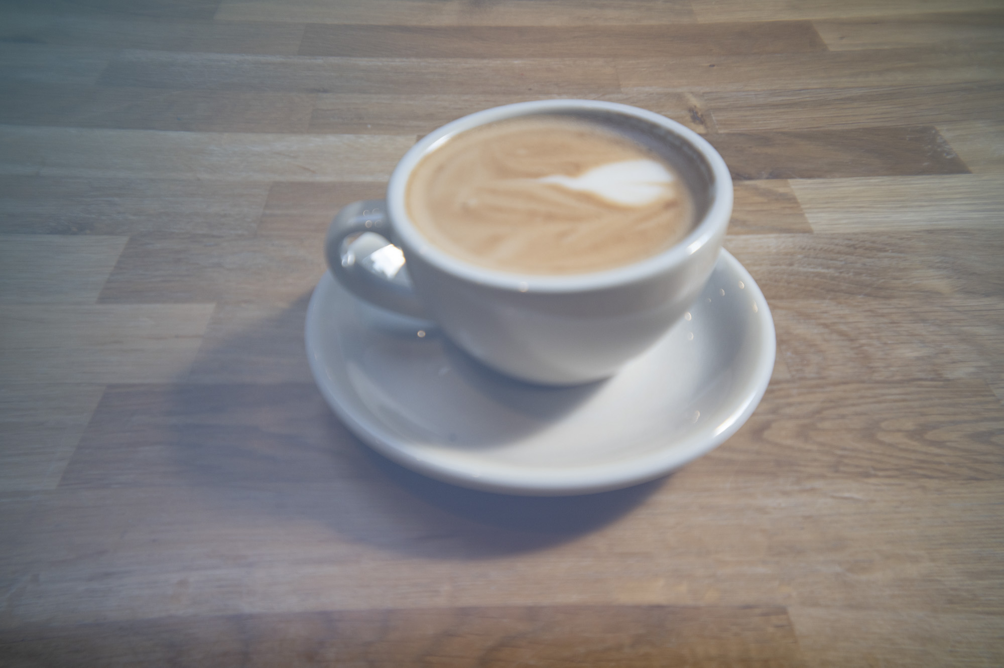 A cup of coffee in a cafe on a wooden surface