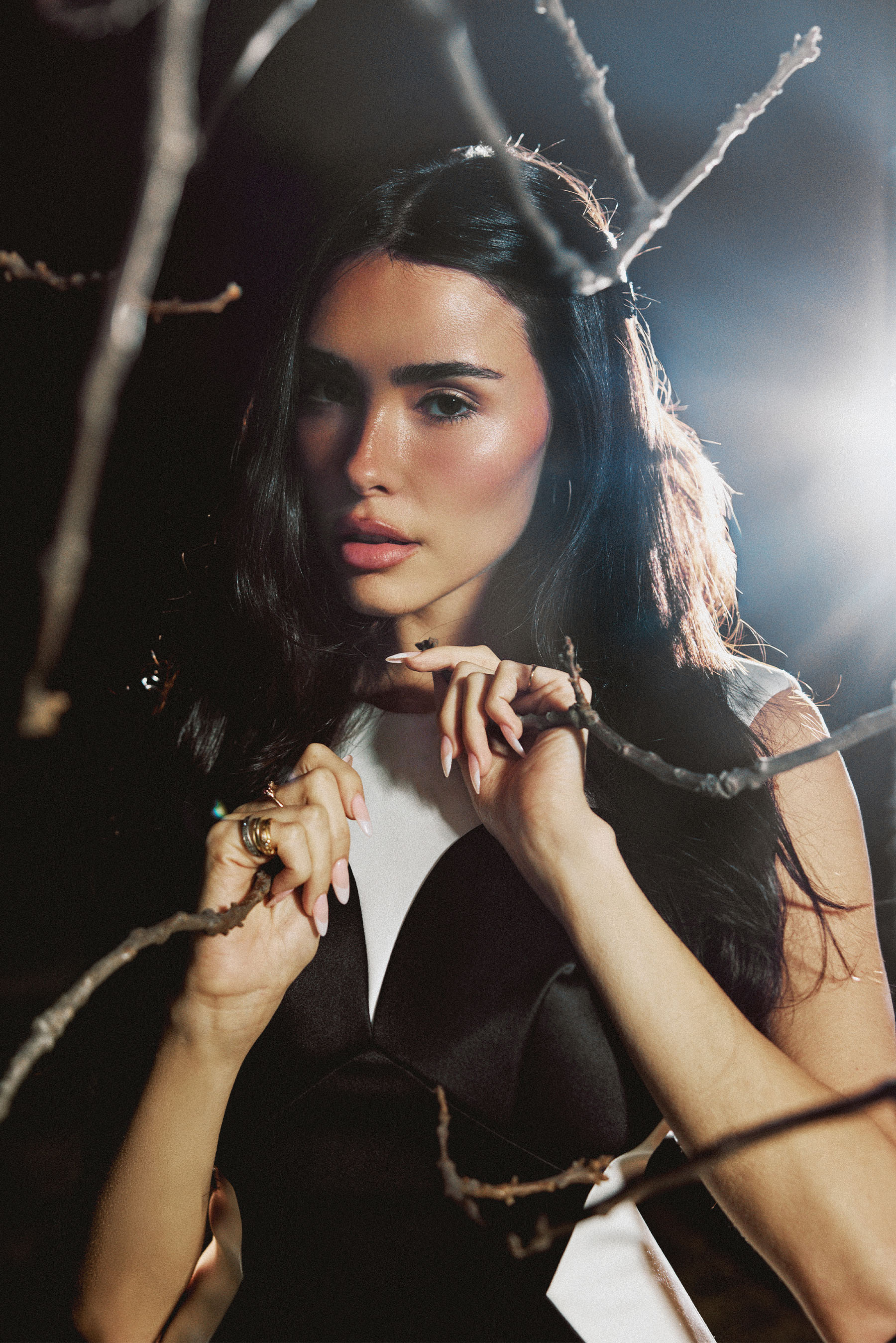 Image from Who What Wear's February cover story with Madison Beer shot by Chantal Anderson. Beer is seen between branches of a tree. She is wearing a black and white Marc Jacobs dress.