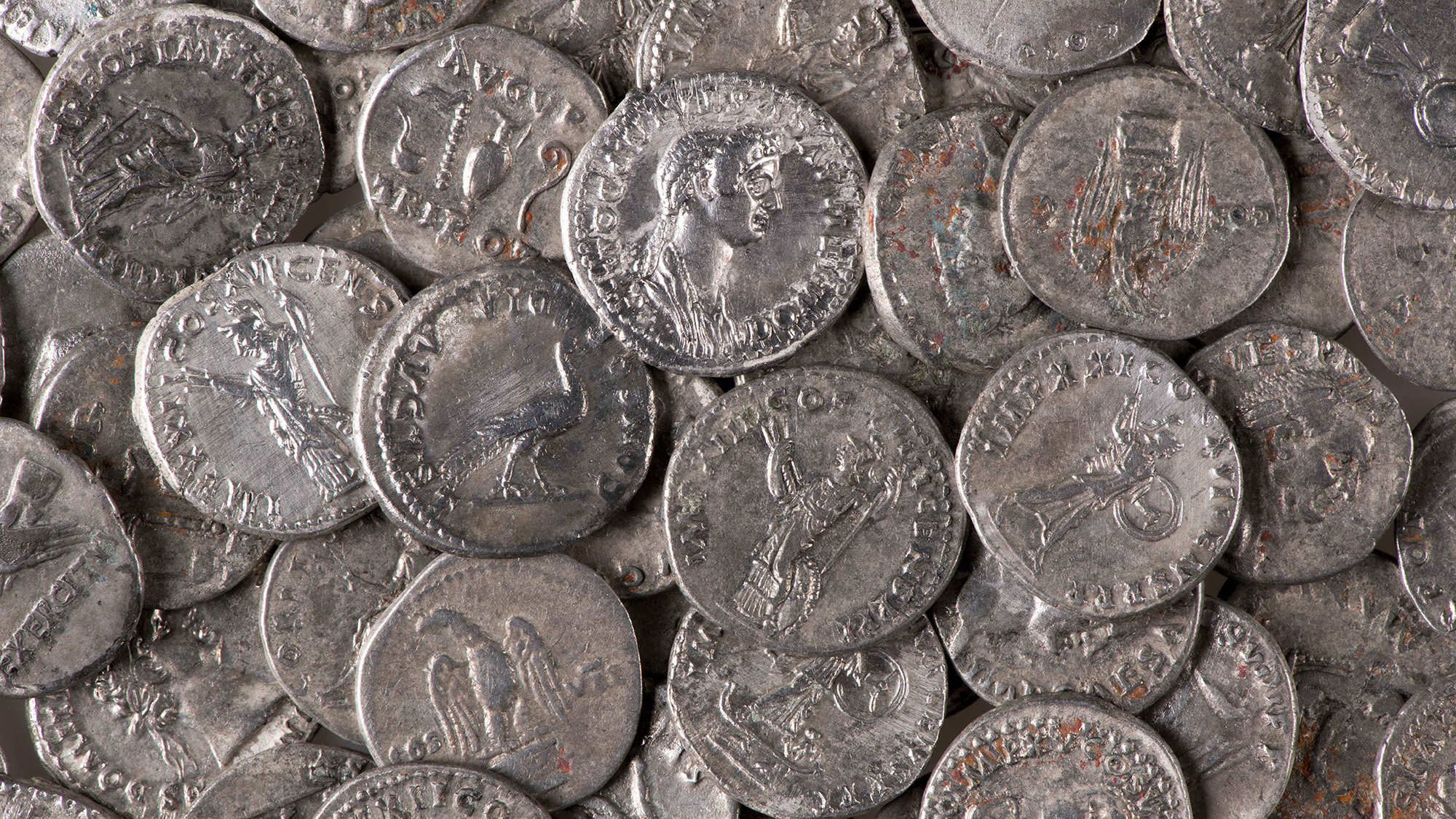 A close up of silver coins with various carvings in them.