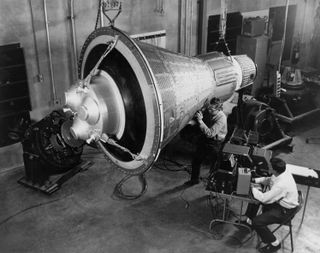 NASA engineers inspect a test Mercury capsule.