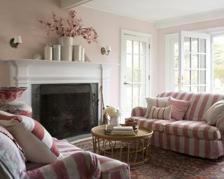 Living room painted in Benjamin Moore Pink Moiré 050 wall paint with striped sofa and cushion