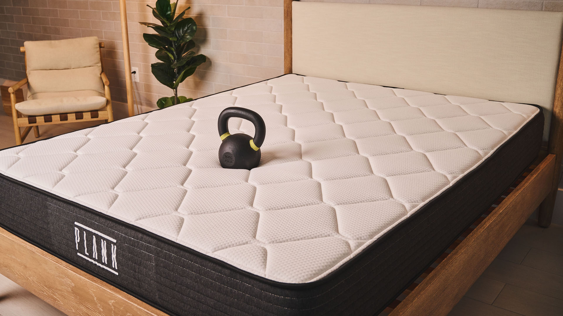 A 50lb weight rests on the middle of the Plank Firm mattress, flipped to the Extra Firm side. The weight hardly sinks into the mattress, demonstrating how firm the memory foam is