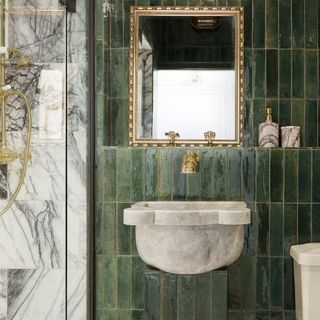 Bathroom with green tiles and gold hardware