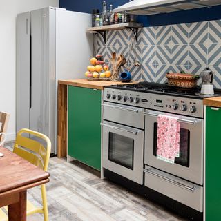 blue texture kitchen wall with gas cooktop and green cabinet