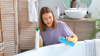 Woman cleaning bathtub