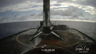The bottom of a rocket standing on landing legs on a floating ship at sea