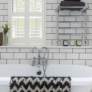 bathroom with white tiled walls and bathtub