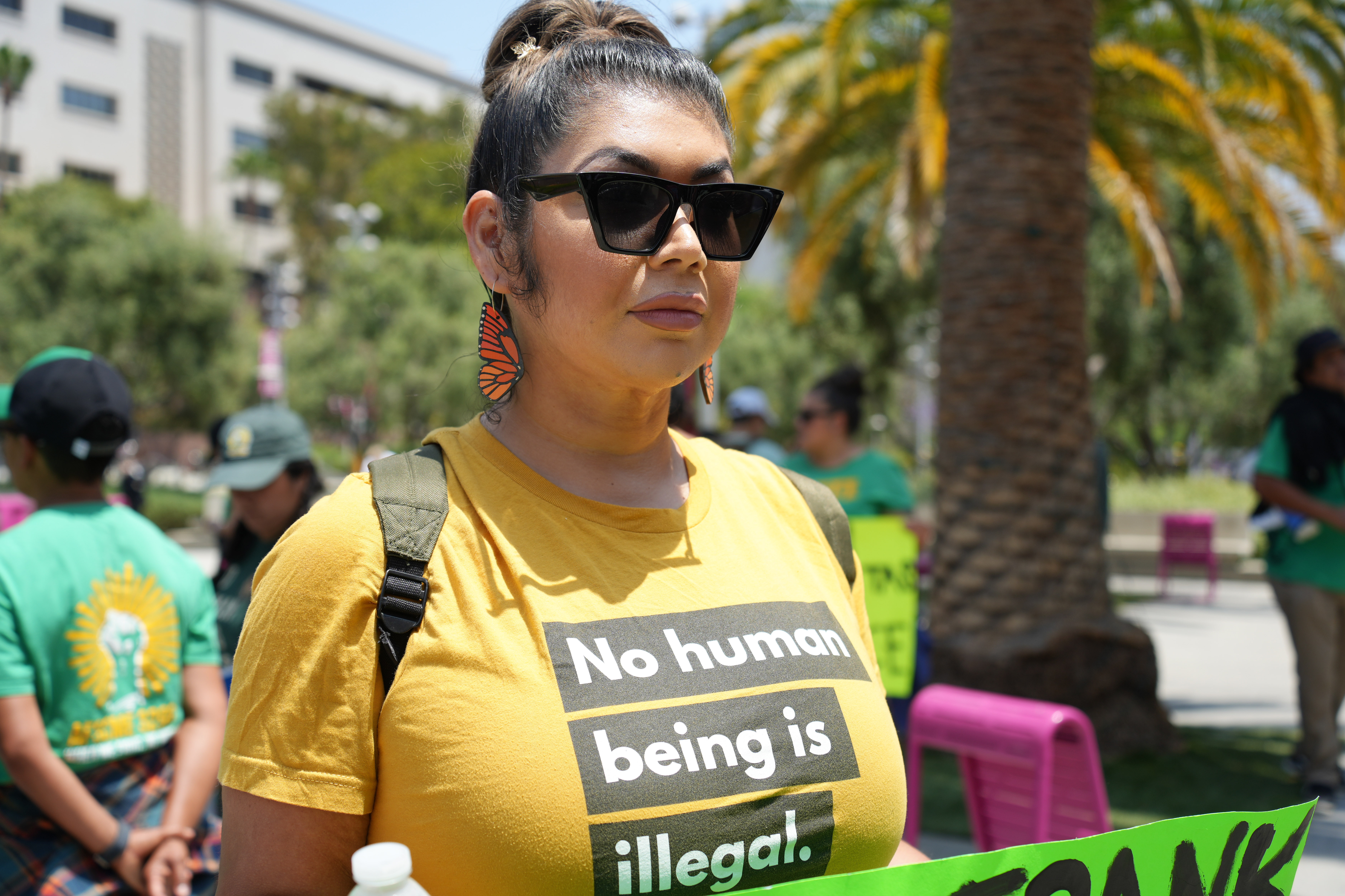 woman wearing a T-shirt that reads “No Human Being Is Illegal.”