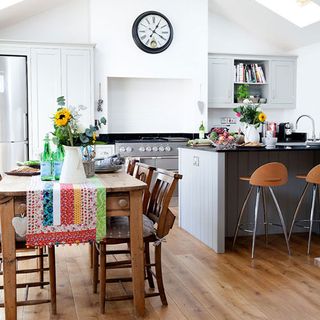 kitchen with dinner and white wall with wooden table and chairs
